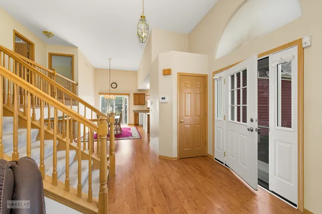 a view of an entryway with wooden floor and door