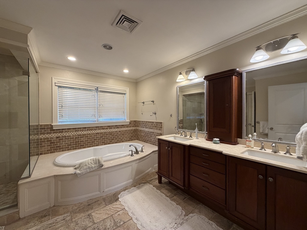 65 Denton Road Wellesley, MA 02482 - Photo 8 of 16 a bathroom with a double vanity sink a large mirror and a bathtub