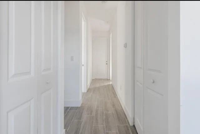 a view of a hallway with wooden floor
