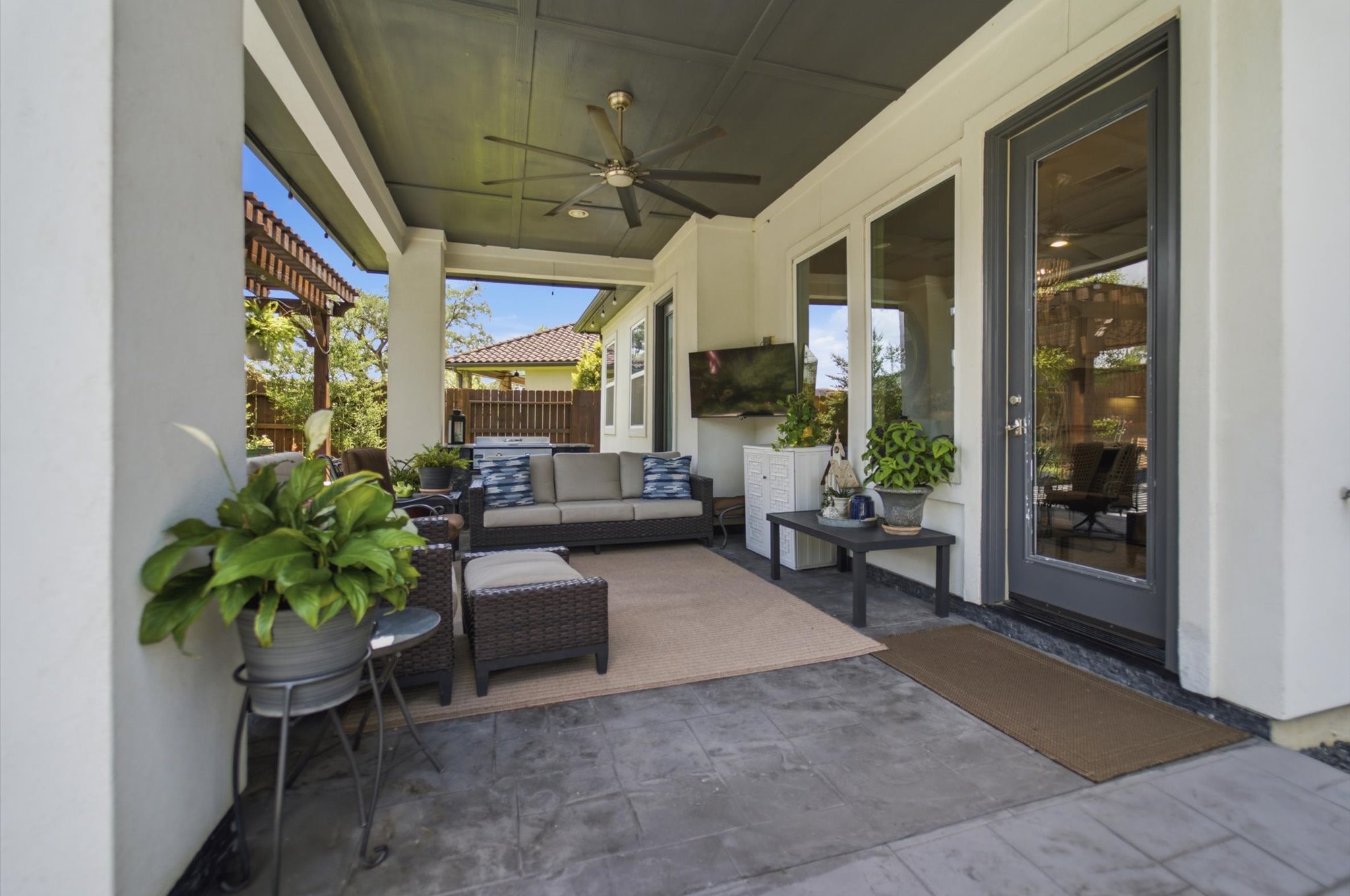23722 Thortons Park Lane Spring, TX 77389 - Photo 45 of 48 This inviting outdoor patio features comfortable wicker seating, a ceiling fan, and lush greenery. It's perfect for relaxing or entertaining, with a view of the garden through large glass doors.