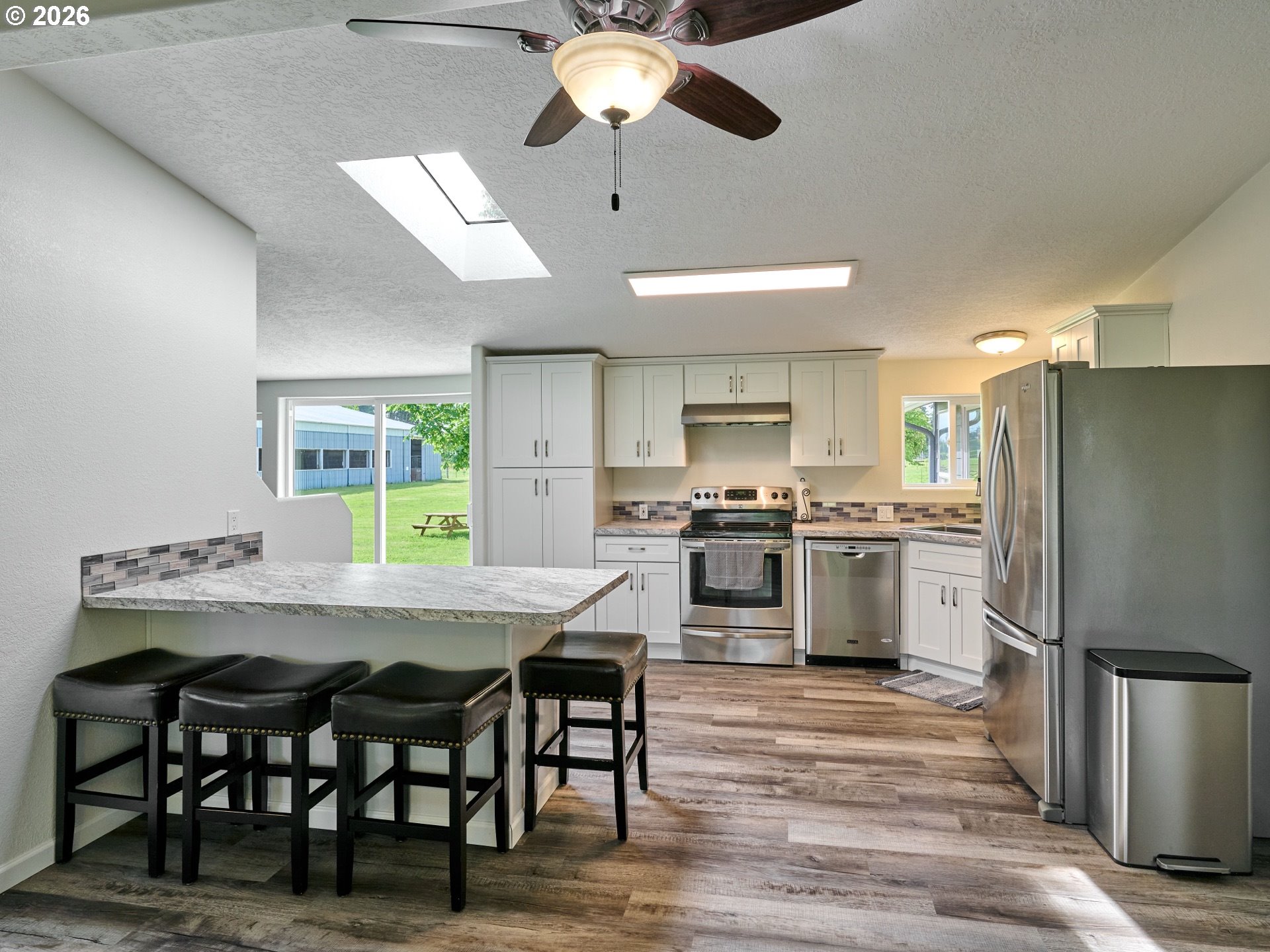 12175 West Stayton Road Southeast Aumsville, OR 97325 - Photo 10 of 48 a kitchen with cabinets wooden floor and stainless steel appliances