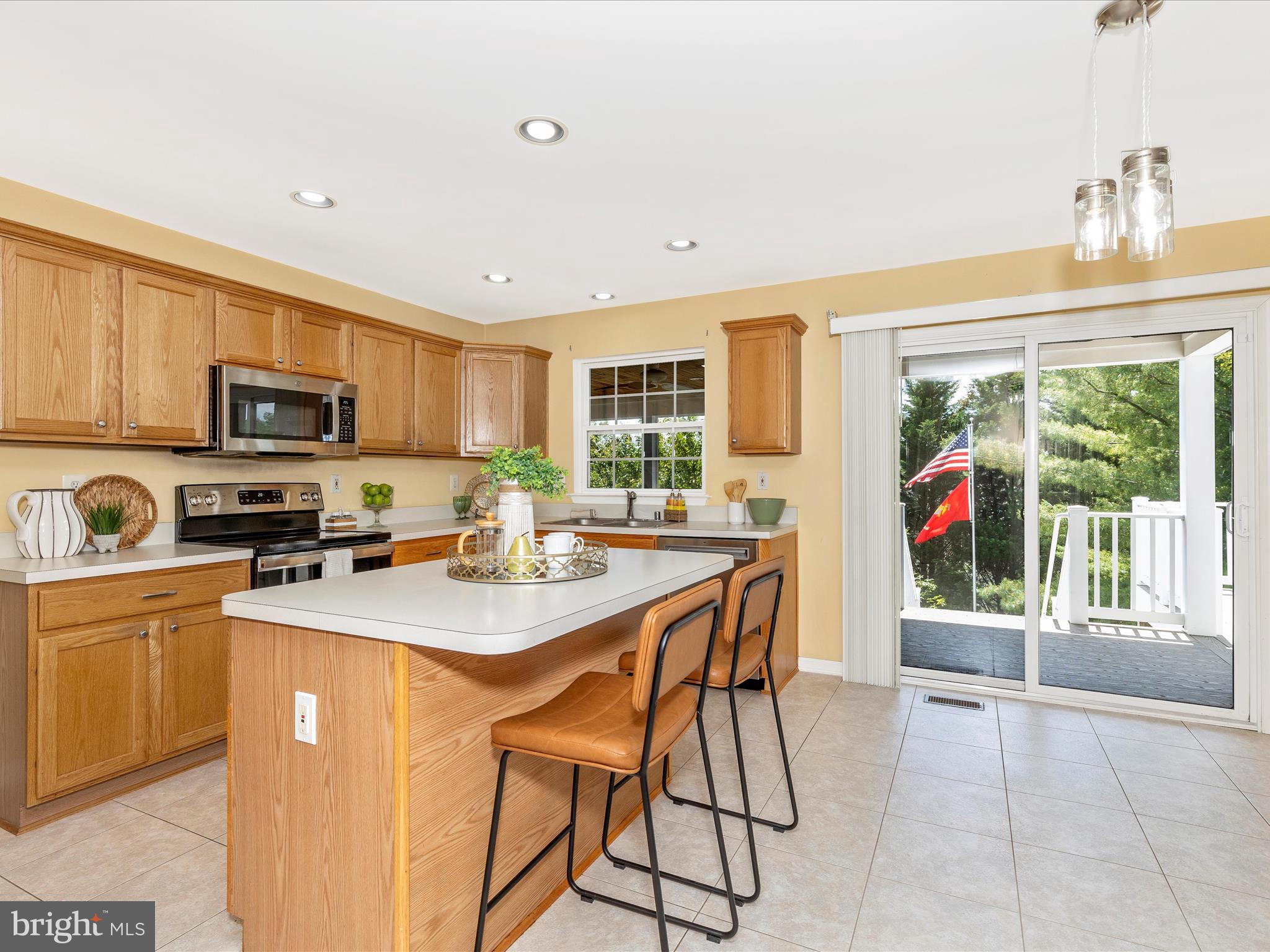 1402 Marian Way Mount Airy, MD 21771 - Photo 11 of 66 a kitchen with stainless steel appliances granite countertop a stove top oven a sink dishwasher a dining table and chairs with wooden floor