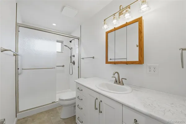 a bathroom with a sink a toilet and shower