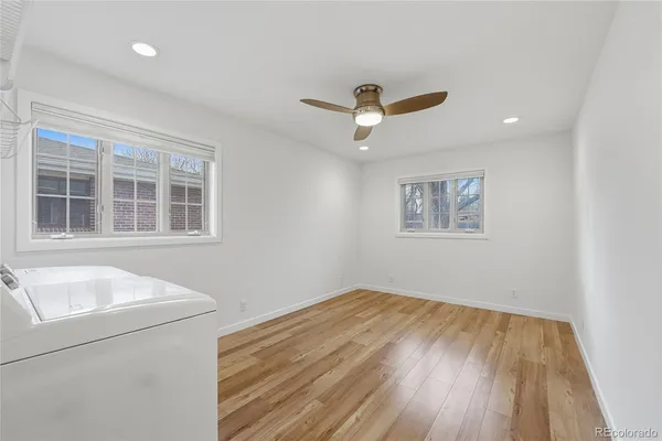 a view of empty room with wooden floor and fan