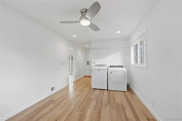 a view of a room with wooden floor and ceiling fan