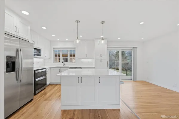 a kitchen with stainless steel appliances granite countertop a stove a sink and a refrigerator