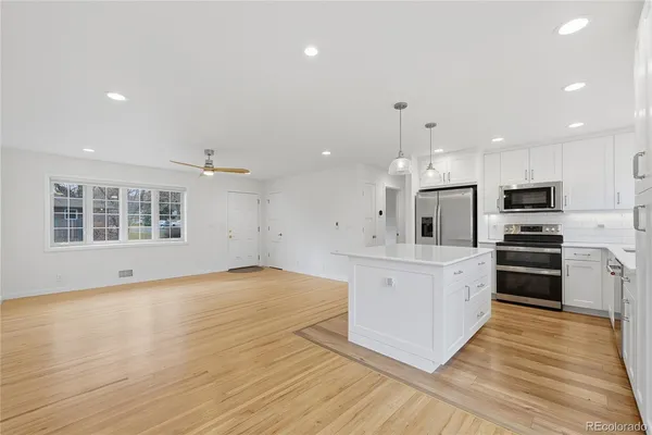 a large kitchen with stainless steel appliances kitchen island granite countertop a stove a sink and a refrigerator