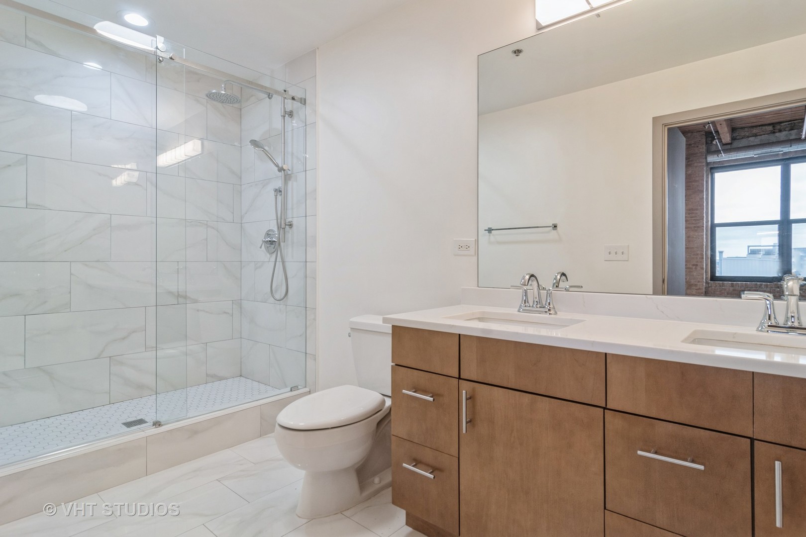 1040 West Adams Street, Unit 608 Chicago, IL 60607 - Photo 12 of 24 a bathroom with a sink toilet a mirror and shower