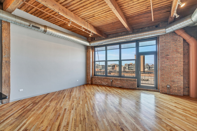 1040 West Adams Street, Unit 608 Chicago, IL 60607 - Photo 7 of 24 a view of an empty room with wooden floor and a window