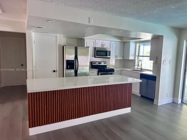 a kitchen with stainless steel appliances a microwave a sink and a refrigerator