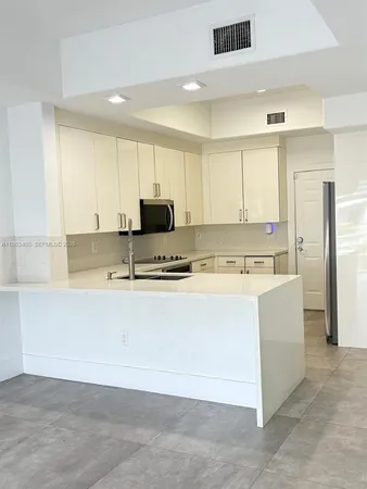 a view of kitchen with stainless steel appliances granite countertop a stove a sink and a refrigerator