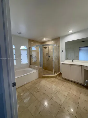 a bathroom with a tub shower and sink