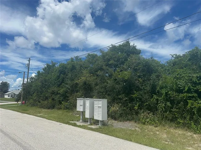 a sign board with buildings in the background