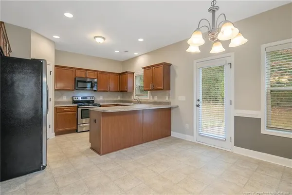 a kitchen with stainless steel appliances granite countertop a refrigerator a sink a stove a microwave and island