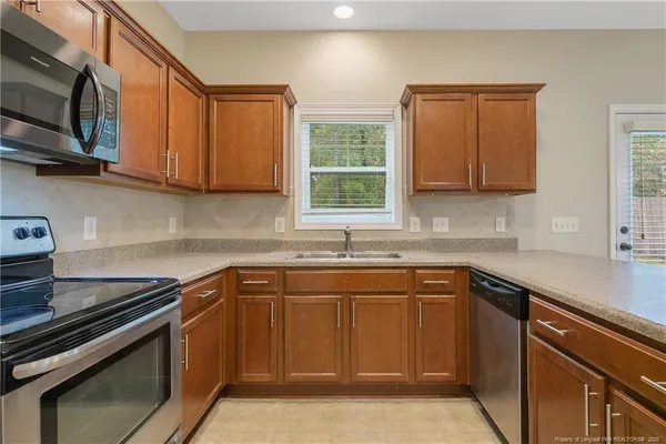 a kitchen with stainless steel appliances granite countertop a sink stove and microwave