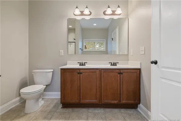 a bathroom with a sink vanity and a toilet