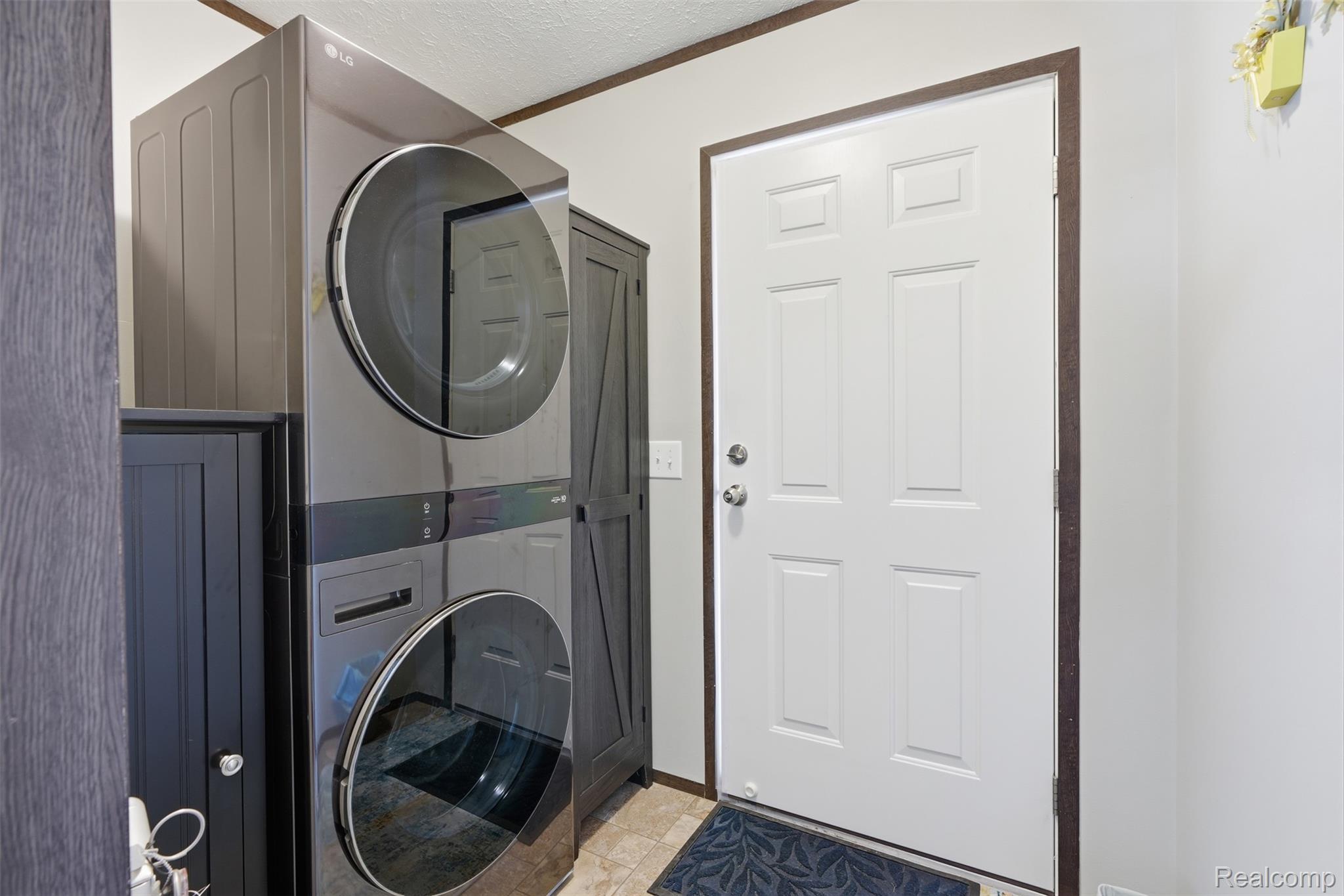 440 Flamingo Street Rochester, MI 48309 - Photo 18 of 32 Laundry area featuring stacked washer and clothes dryer and a textured ceiling