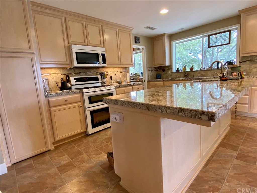 7605 San Gregorio Road Atascadero, CA 93422 - Photo 8 of 22 a kitchen with stainless steel appliances granite countertop a stove a sink and a microwave