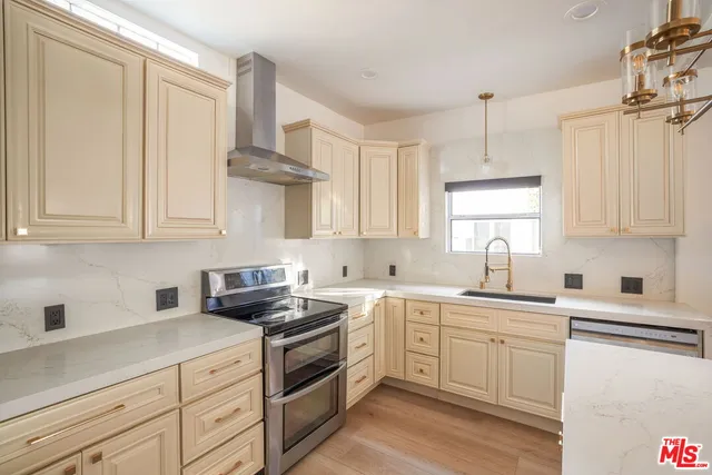 a kitchen with stainless steel appliances a sink stove and cabinets