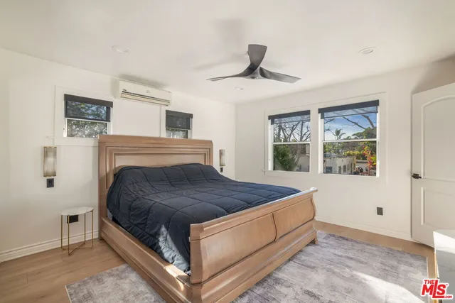 a spacious bedroom with a bed and a flat screen tv