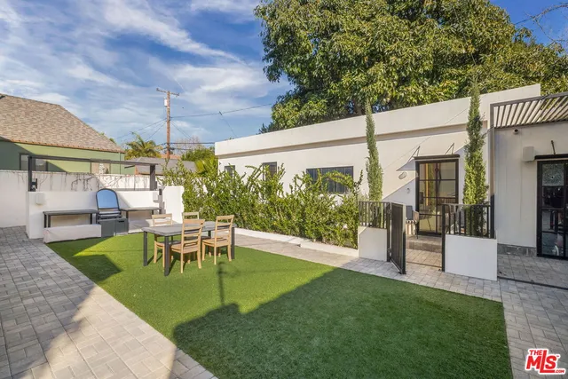 a view of a patio with table and chairs potted plants with wooden fence