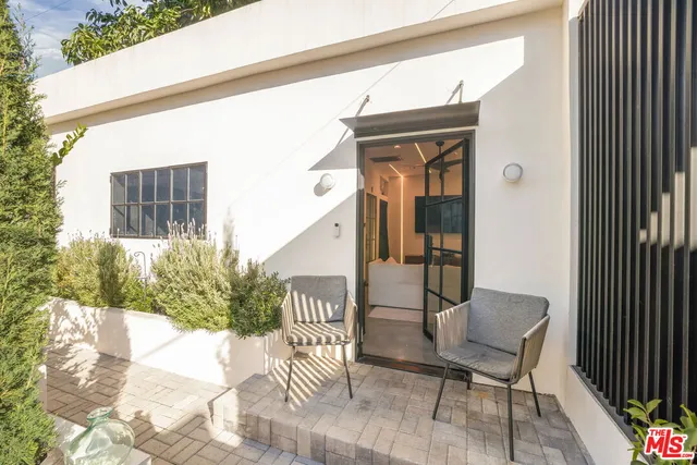a living room with furniture a flat screen tv and kitchen view