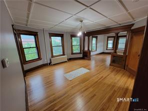 393 Highland Avenue, Unit 2 Waterbury, CT 06708 - Photo 3 of 10 an empty room with wooden floor and windows
