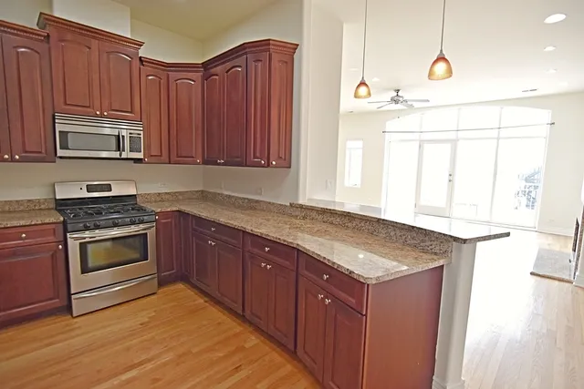 a kitchen with stainless steel appliances granite countertop a stove a sink and a microwave