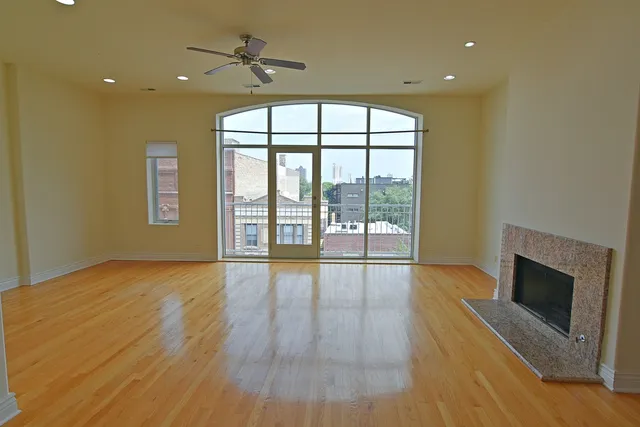 a view of an empty room with a fireplace and a window