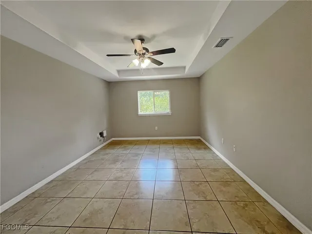 an empty room with windows and ceiling fan