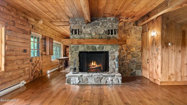 a view of empty room with wooden floor and fireplace