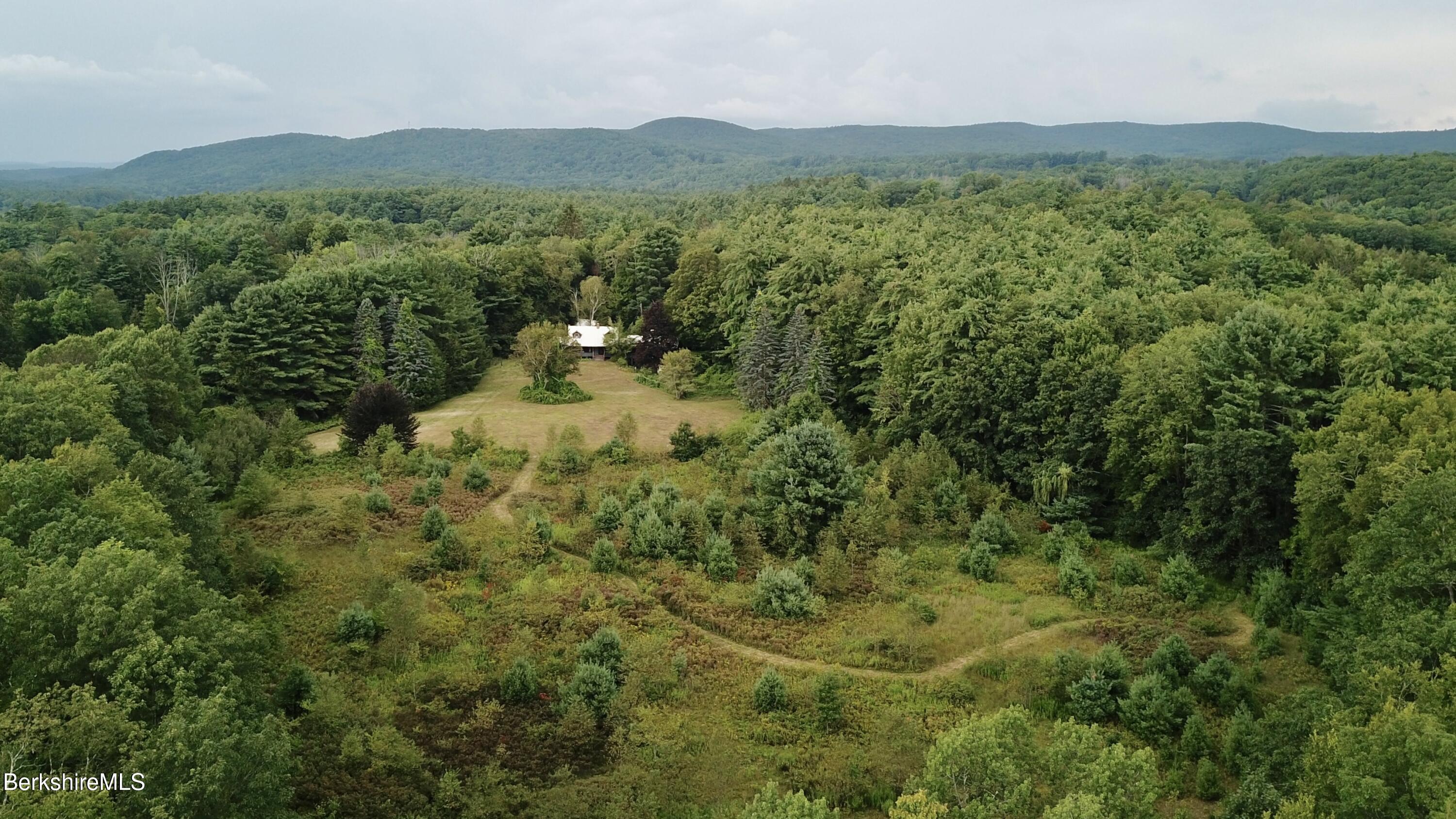 76 Corashire Road New Marlborough, MA 01230 - Photo 31 of 31 a view of a lush green hillside and a houses