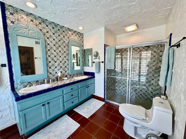 a bathroom with a double vanity sink toilet mirror and shower