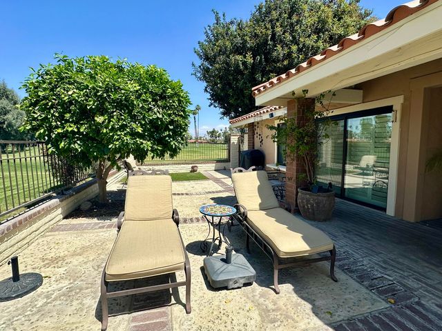 a view of a patio with table and chairs and potted plants with wooden floor and fence