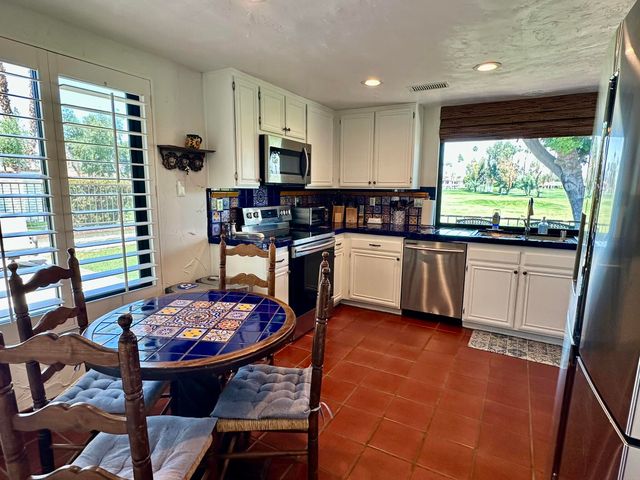 a kitchen with a table chairs sink and cabinets