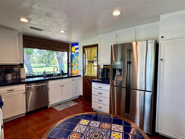 a kitchen with stainless steel appliances granite countertop a refrigerator stove microwave and sink