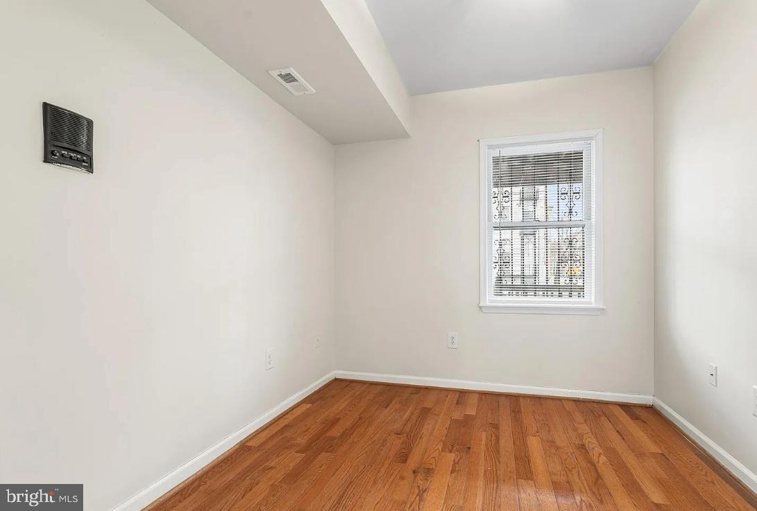 1401 Druid Hill Avenue, Unit B Baltimore, MD 21217 - Photo 11 of 23 an empty room with wooden floor and windows
