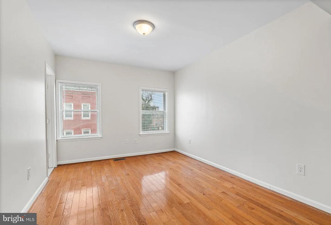 1401 Druid Hill Avenue, Unit B Baltimore, MD 21217 - Photo 16 of 23 an empty room with wooden floor and windows