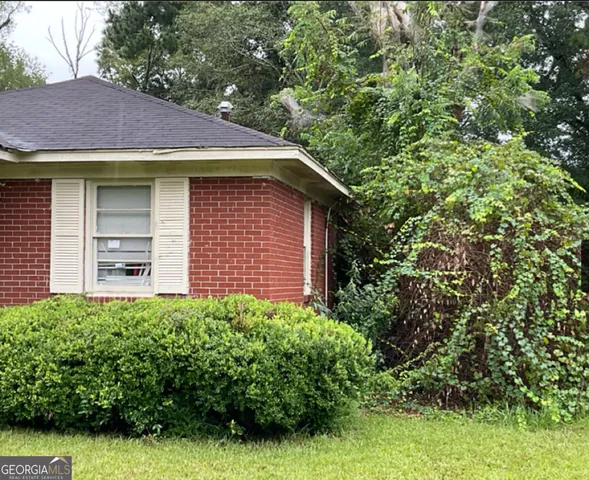 a view of a house with potted plants and a tree