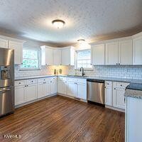 600 Schenley Road Knoxville, TN 37923 - Photo 4 of 38 a kitchen with granite countertop white cabinets and white appliances