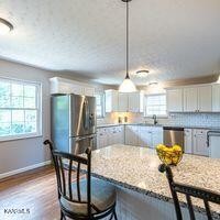600 Schenley Road Knoxville, TN 37923 - Photo 6 of 38 a kitchen with stainless steel appliances granite countertop sink refrigerator dining table and chairs