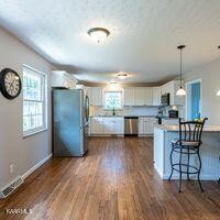 600 Schenley Road Knoxville, TN 37923 - Photo 10 of 38 a kitchen with stainless steel appliances granite countertop a refrigerator a stove a microwave oven a dining table and chairs with wooden floor