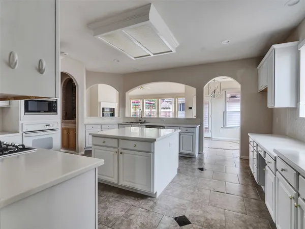 a large kitchen with stainless steel appliances a stove a sink dishwasher and cabinets