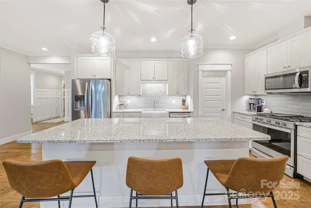 a kitchen with stainless steel appliances granite countertop a kitchen island a stove and a cabinets