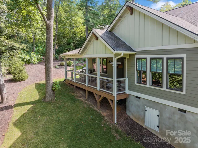 a view of house with a big yard potted plants and large tree