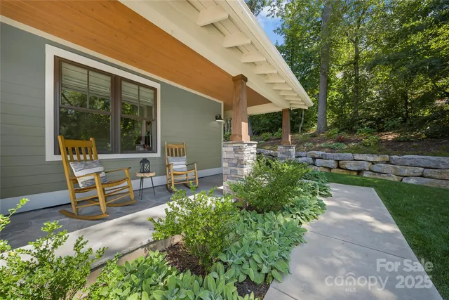 a view of a patio with table and chairs potted plants and large tree