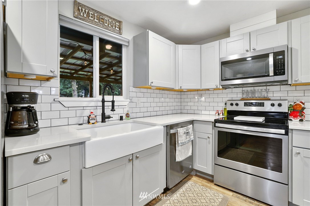 18625 Nutmeg Street Southwest Rochester, WA 98579 - Photo 4 of 18 a kitchen with stainless steel appliances a stove microwave and sink