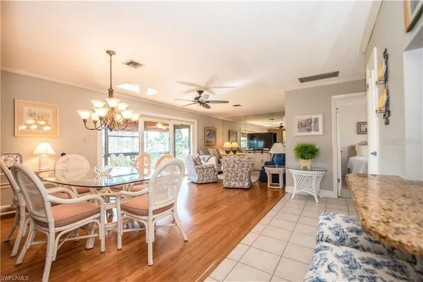 a living room with furniture a chandelier and a dining table