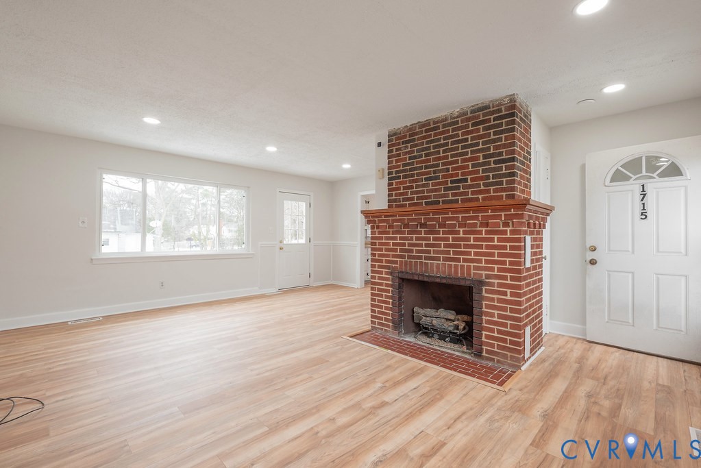 1715 West City Point Road Hopewell, VA 23860 - Photo 4 of 22 an empty room with wooden floor fireplace and windows