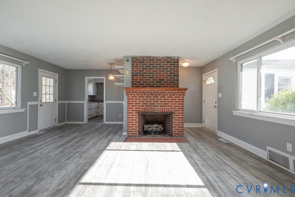 1715 West City Point Road Hopewell, VA 23860 - Photo 5 of 30 an empty room with wooden floor fireplace and windows